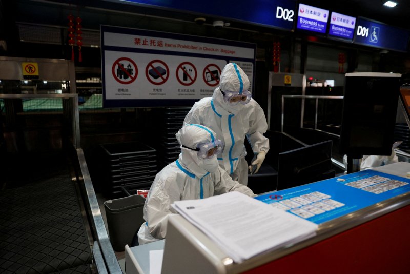 코로나19가 실험실이 아니라 중국 우한에서 거래되던 너구리에서 인간에게 옮겨왔을 가능성이 제기됐다. 지난해 3월 13일 중국 베이징 국제공항에서 항공사 직원들이 방호복을 입고 발권 창구에서 일하고 있다. 로이터뉴스1