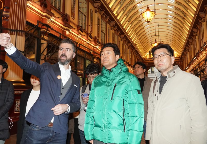 오세훈 시장이 13일(현지시간) 런던 리덴홀 마켓에서 로저스 스터크 하버+파트너스(RSHP) 관계자로부터 주변 건물에 대한 설명을 듣고 있다. 왼쪽부터 존 맥엘건 RSHP 파트너, 오세훈 서울시장, 조남준 서울시 도시계획국장. (서울시 제공)