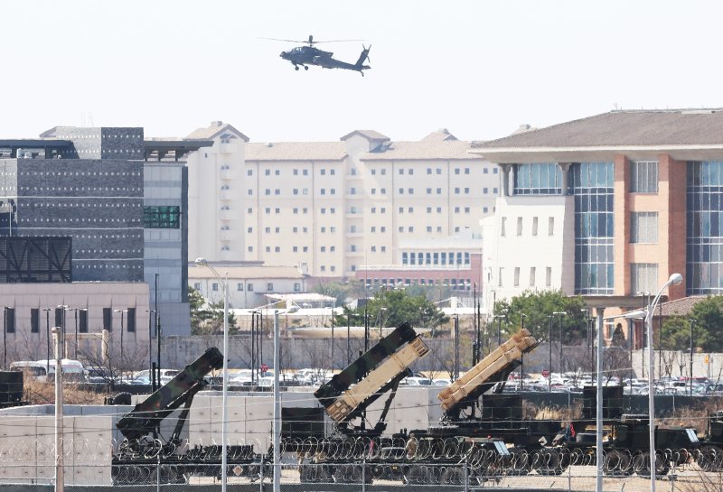 연합연습에 반발해 단거리탄도미사일 2발을 발사한 지난 2023년 4월 13일 경기도 평택시 캠프 험프리스에 배치된 패트리엇 미사일 위로 아파치 헬기가 비행하고 있다. 연합뉴스