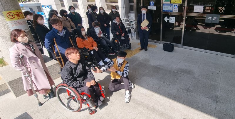 지난 3월 광주지법에서 지역 장애인 단체 회원들이 광주시와 금호고속 등을 상대로 고속버스에 휠체어 탑승 설비를 설치하지 않은 것은 차별이라며 제기한 차별 구제 청구 소송 재판 방청을 마친 뒤 인터뷰하고 있다./사진=뉴시스