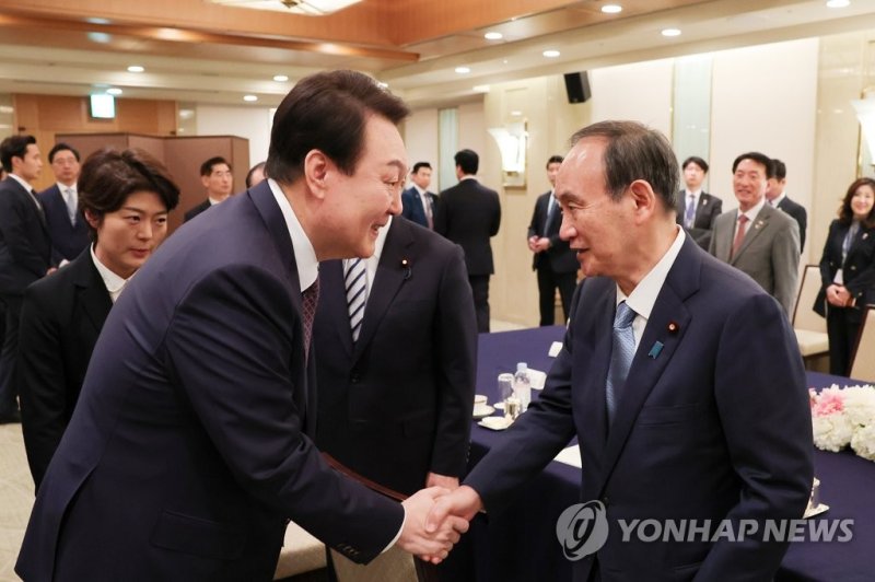 1박2일 일정으로 일본을 방문한 윤석열 대통령이 17일 도쿄 한 호텔에서 열린 일한 친선단체 및 일본 정계 지도자를 접견에서 일한의원연맹 회장에 취임하는 스가 요시히데 전 총리와 인사하고 있다 . 연합뉴스