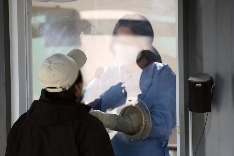 지난 13일 서울 용산구보건소 코로나19 선별 진료소에서 한 시민이 검사를 받는 모습. 뉴스1