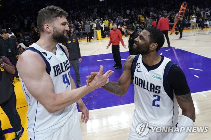 댈러스의 막시 클레버(왼쪽)와 카이리 어빙 Dallas Mavericks forward Maxi Kleber, left, shakes hands with Dallas Mavericks guard Kyrie Irving (2) after Kleber made the game-winning 3-point basket as time expired during the second half of an NBA basketball game against the Los Angeles Lakers Friday, March 17, 2023, in L