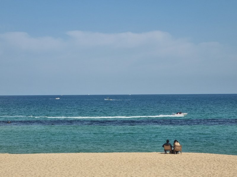 완연한 봄 날씨를 보인 18일 강원 강릉 안목커피해변에서 나들이객 앞으로 모터보트가 지나가고 있다.2023.3.18/뉴스1 윤왕근 기자