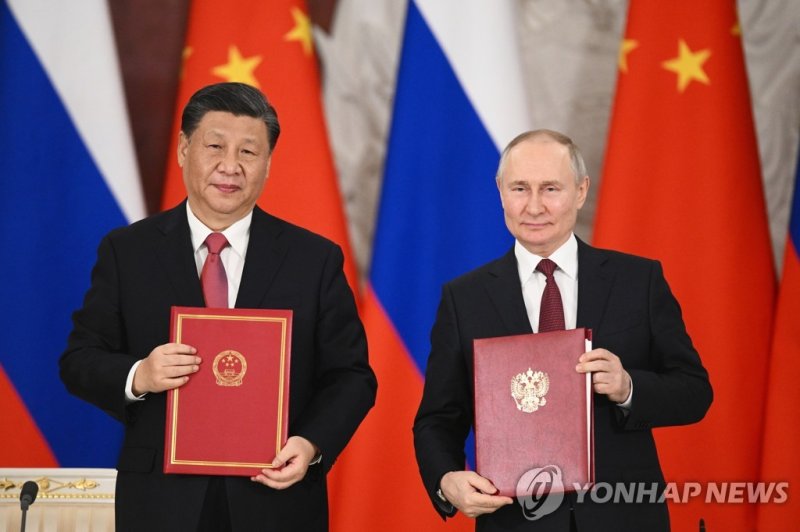 시진핑 중국 국가주석(왼쪽)과 블라디미르 푸틴 러시아 대통령이 21일(현지시간) 모스크바 크렘린궁에서 정상회담 공동 성명에 서명한 뒤 기념 촬영을 하고 있다. 사진=연합뉴스