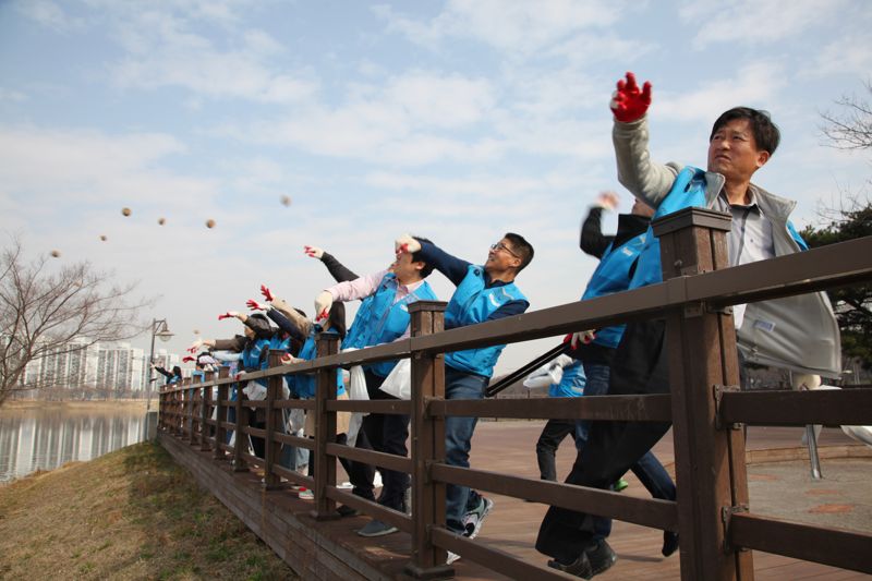 경기 안산도시공사 임직원들이 22일 세계 물의 날을 맞아 진행된 EM흙공 던지기 행사에 참여하고 있다. 사진=안산도시공사