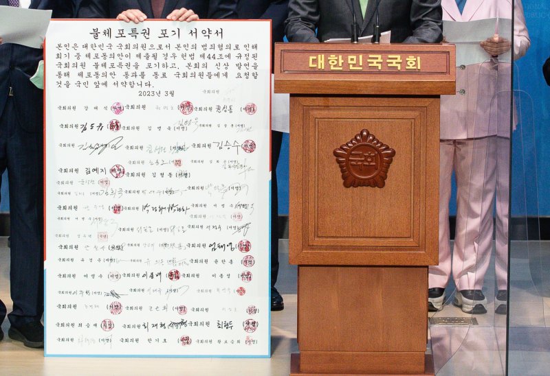 23일 서울 여의도 국회 소통관에서 열린 국민의힘 의원 불체포특권 포기 서약서 대국민 기자회견에서 한 의원이 불체포특권 포기 서약에 참여한 의원들의 명판을 들고 있다. 2023.3.23/뉴스1 ⓒ News1 유승관 기자