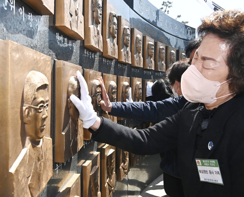 [평택=뉴시스] 김종택 기자 = 26일 경기도 평택시 해군 제2함대 사령부에서 열린 '제13주기 천안함 46용사 추모식'에서 유가족이 추모비에 새겨진 얼굴을 어루만지고 있다. 이날 열린 추모식에는 당시 숨진 군인 유가족과 천암함 승조원, 해군 관계자 등 200여 명이 참석했다. 2023.03.26. jtk@newsis.com