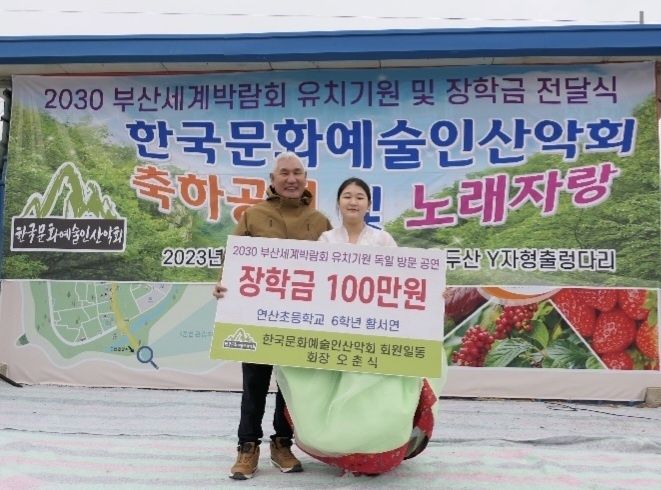 오춘식 한국문화예술산악회 회장이 부산연산초등학교 6학년 황서연 학생에게 장학금을 지급한 후 기념사진을 찍고 있다./제공=한국문화예술인산악회