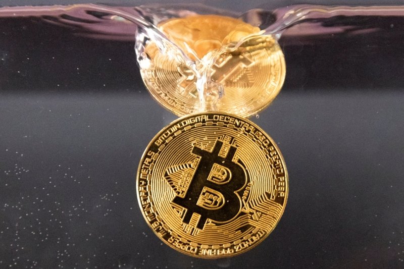 FILE PHOTO: Souvenir tokens representing cryptocurrency Bitcoin plunge into water in this illustration taken May 17, 2022. REUTERS/Dado Ruvic/Illustration/File Photo