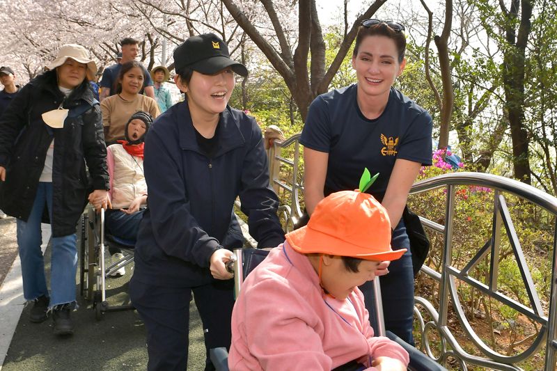 29일 해군작전사령부와 미 항모강습단 장병들이 거제시에 위치한 장애인 복지시설 애광원에 방문해 원생의 휠체어를 끌어주고 이야기 나누며 즐거운 시간을 보내고 있다./제공=해군