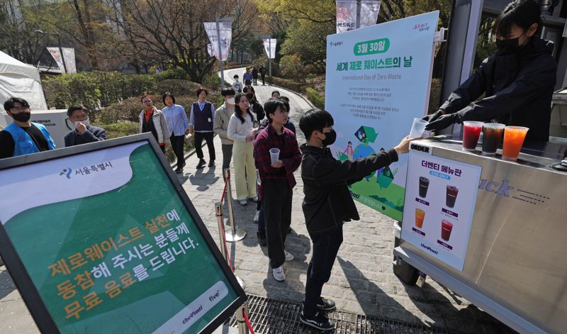 유엔(UN) 지정 '제1회 세계 쓰레기 없는 날'인 30일 서울 중구 정동길에서 서울시가 운영하는 제로 웨이스트 실천 커피차에서 시민들이 서울시 다회용컵에 무료 음료를 받고 있다. 이날 운영한 커피차는 텀블러를 지참한 시민들에게 무료 음료를 제공했다. 텀블러를 지참하지 않은 시민에게도 서울시 다회용컵(보증금 1천원)에 무료로 음료를 받을 수 있도록 했다. 사진=서동일 기자