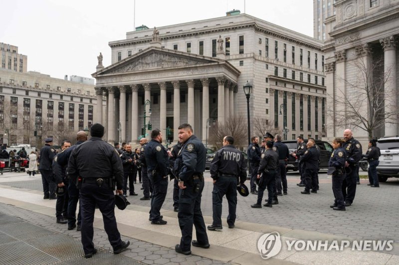 뉴욕시 맨해튼 형사법원과 맨해튼지검 청사 앞에 배치된 경찰관들 New York police officers gather near the Manhattan criminal court and Manhattan District Attorney's office in New York City on March 22, 2023. - With barricades set up near Trump Tower and police on high alert, New York was holding its breath Wednesday for the like