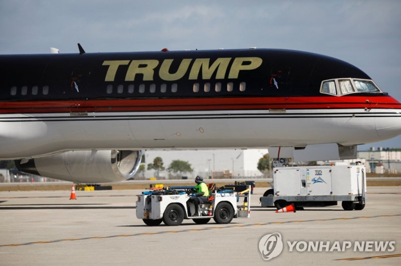 플로리다주 팜비치공항에 있는 트럼프 전용기 A man rides a ground support vehicle near a plane of former U.S. President Donald Trump at the Palm Beach International Airport, days after he posted a message on his Truth Social account saying that he had expected to be arrested, and called on his supporters to protest, in 