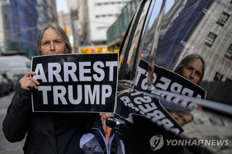 뉴욕에서 트럼프 체포 촉구하는 시위자 Anti-Trump demonstrators protest outside the Manhattan District Attorney's office in New York City on March 22, 2023. - With barricades set up near Trump Tower and police on high alert, New York was holding its breath Wednesday for the likely indictment of Donald Trump, but the 