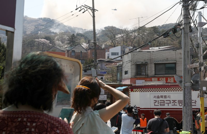 서울 종로구 인왕산에서 지난 2일 발생한 화재 진화 작업을 벌이고 있는 것을 마을 주민들이 지켜보고 있다. 뉴시스