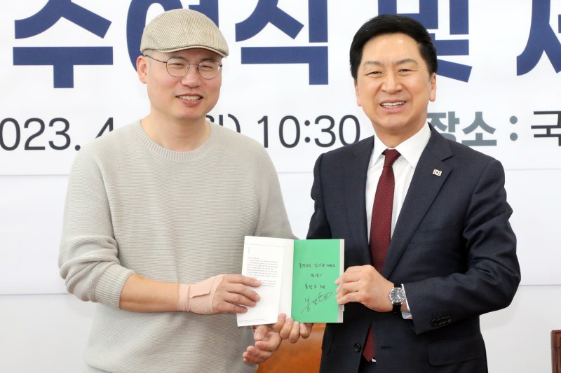 김기현 국민의힘 대표와 곽대중(필명 봉달호) 위원이 지난 4월 3일 오전 국회에서 열린 민생119 임명장 수여식 및 제1차 회의에서 곽 위원 사인이 담긴 에세이집 '셔터를 올리며'를 함께 들어 보이고 있다. 뉴스1