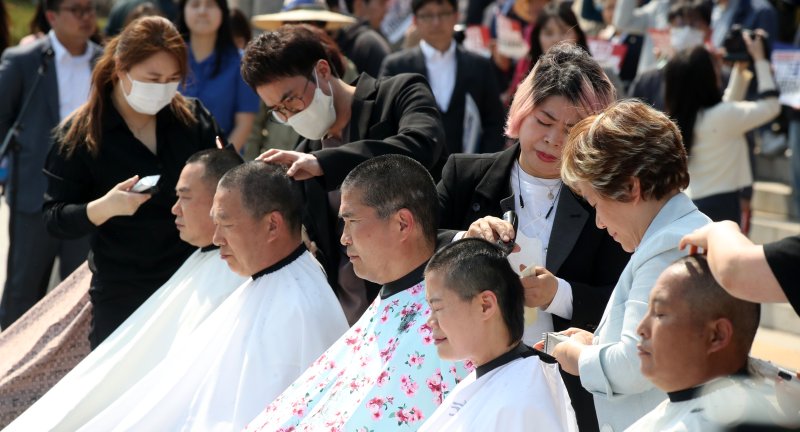 [서울=뉴시스] 고범준 기자 = 신정훈(왼쪽 두번째부터), 이원택 더불어민주당 의원, 농민 등이 3일 오후 서울 여의도 국회 본청 앞 계단에서 열린 쌀값 정상화법 공포 촉구 결의대회에서 삭발을 하고 있다. 2023.04.03. bjko@newsis.com