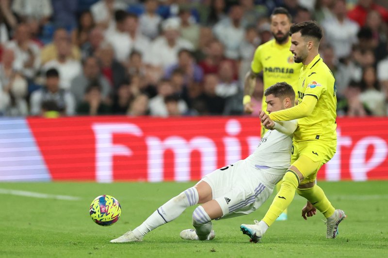 TOPSHOT - Real Madrid's Uruguayan midfielder Federico Valverde (L) vies with Villarreal's Spanish midfielder Alex Baena during the Spanish league football match between Real Madrid CF and Villarreal CF at the Santiago Bernabeu stadium in Madrid on April 8, 2023. (Photo by Pierre-Philippe MARCOU / AF