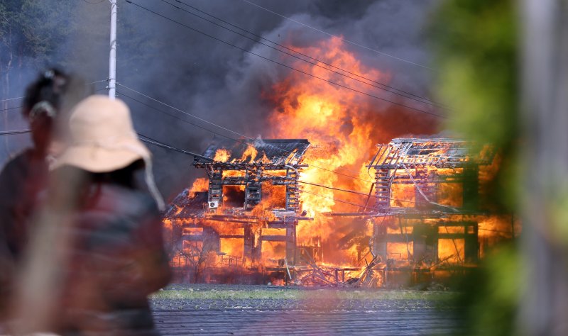 11일 강원 강릉시 야산에서 시작된 산불이 인근 주택가까지 번지면서 주민들이 대피하고 있다. 불타는 집들을 주민들이 바라보고 있다. 연합뉴스
