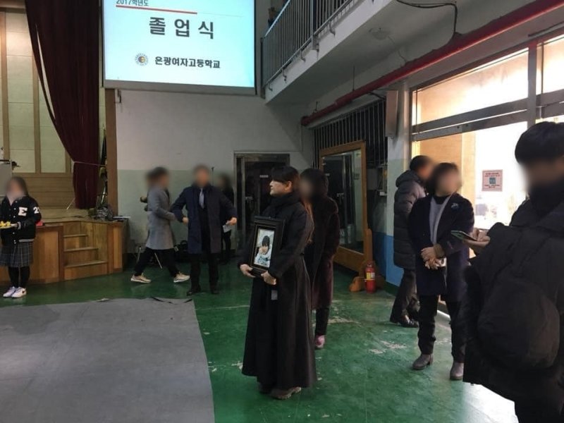 학폭 피해자 고(故) 박주원양의 어머니 이기철씨가 2018년 은광여고 졸업식에 딸의 영정사진을 들고 참석했다. (이기철씨 페이스북)