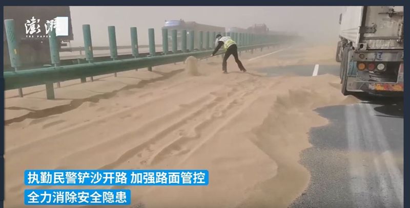 지난 10일 중국 네이멍구자치구 바옌나오얼시 도로에 쌓인 모래를 경찰이 제거하는 모습. 사진=중국 매체 캡처.