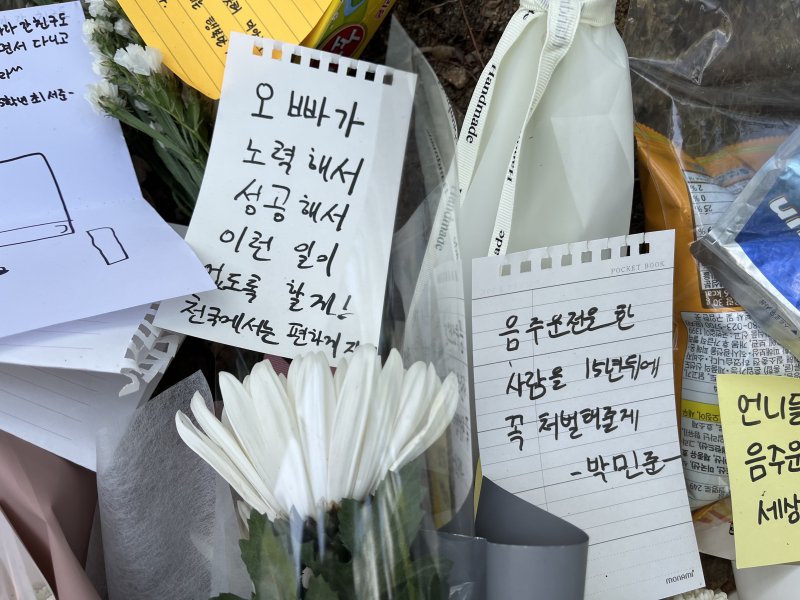 지난달 10일 오전 대전 서구 둔산동의 한 초등학교 인근에 음주운전 사고로 사망한 9살 초등학생을 추모하기 위한 쪽지가 꽃과 함께 놓여있다. 뉴시스 제공