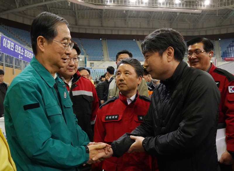 한덕수 국무총리(왼쪽)와 남성현 산림청장(가운데)이 강릉 산불피해 이재민인 강릉국유림관리소 소속 산불재난특수진화대원을 위로하는 모습. (산림청제공) 뉴스1