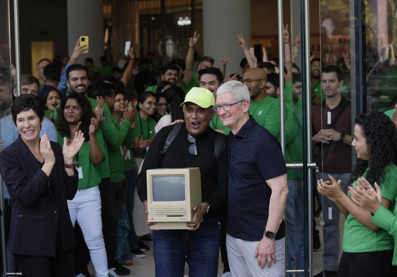 지난 4월18일(현지시간) 인도 뭄바이의 애플 스토어 개점식에 참석한 팀 쿡 최고경영자(CEO)(오른쪽 두번째)가 애플의 구형 기종인 매킨토시 제품을 들고온 소비자와 기념 사진을 찍고 있다.AP뉴시스