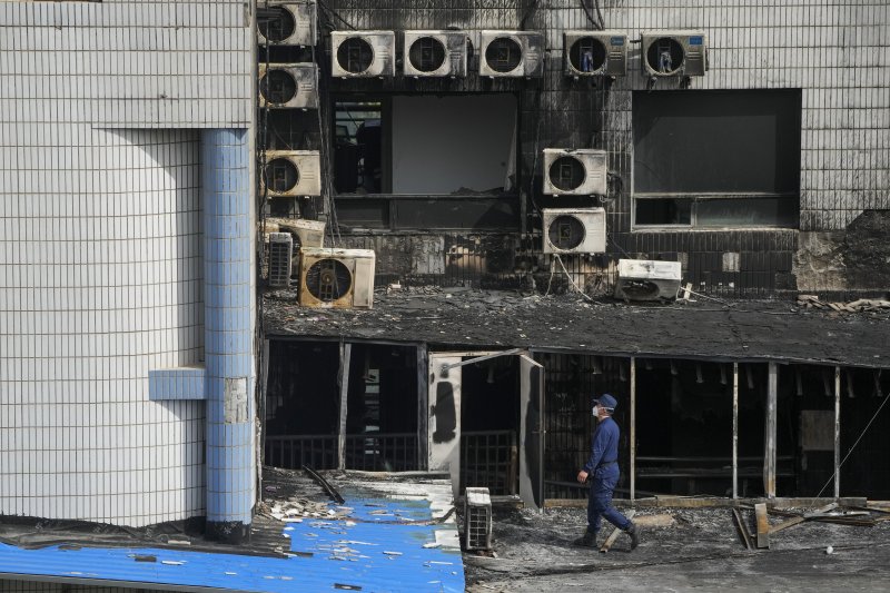 19일 중국 베이징 펑타이구 창펑병원 입원병동에서 소방 당국 관계자가 불이 난 건물을 조사하고 있다.AP뉴시스