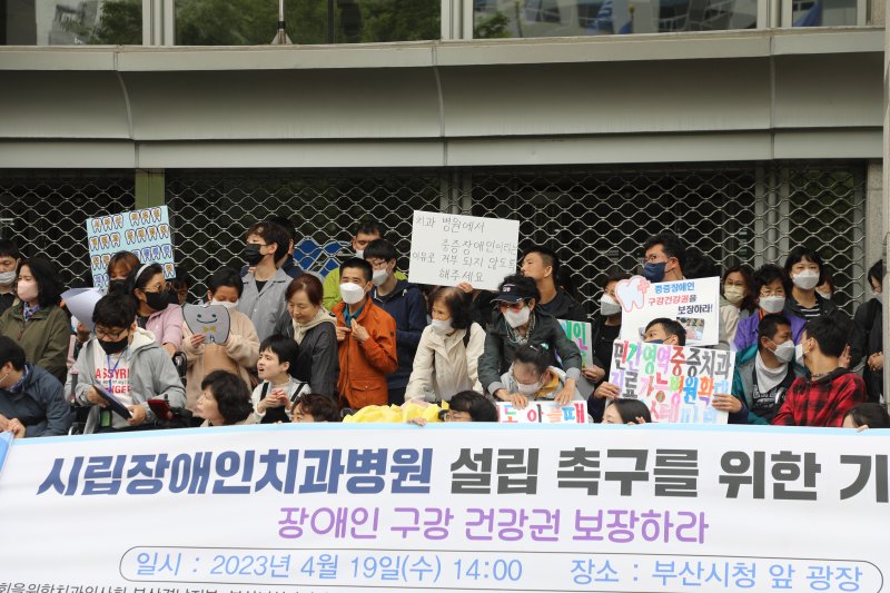 19일 부산시청 앞에서 열린 '장애인치과병원 설립 촉구를 위한 기자회견에서 중증장애인과 그의 가족들이 피켓을 들고 있다.2023.4.19/뉴스1 ⓒ News1 조아서 기자