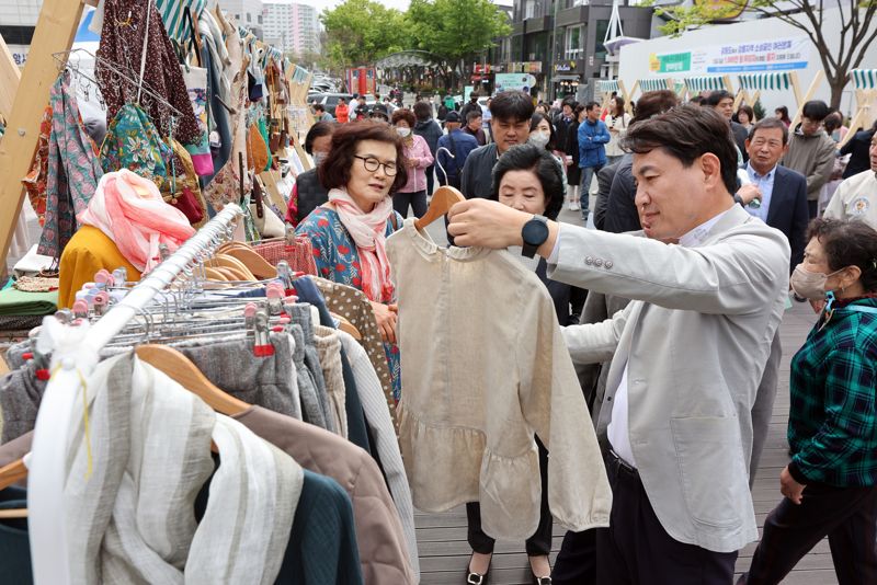 김진태 강원도지사가 22일 강릉 월화거리에서 열린 산불 피해극복을 응원하는 플리마켓을 찾아 물건을 들어보고 있다. 강원도 제공.