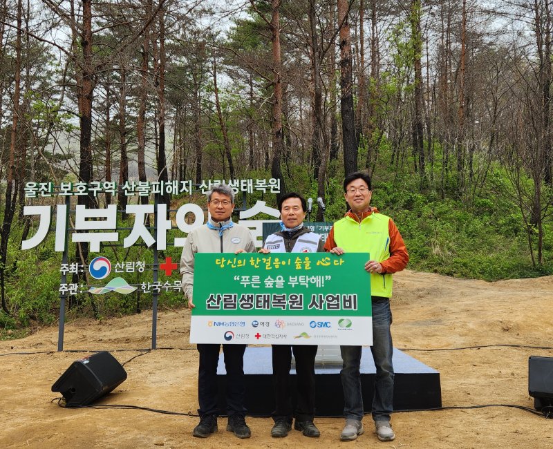 금동명 NH농협은행 부행장(오른쪽 첫번째), 김재왕 대한적십자사 경북지사 회장(오른쪽 두번째), 류광수 한국수목원정원관리원 이사장이 지난 21일 경북 울진군 산불피해지 '기부자의 숲'에서 산림생태복원 행사에 참여해 기념촬영을 하고 있다. NH농협은행 제공