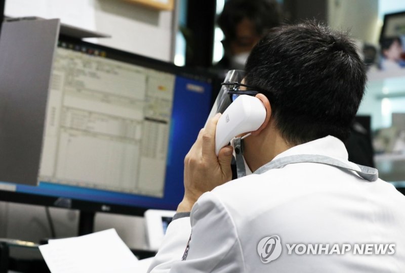 지난해 2월 서울 중구 한 병원에서 의사가 전날 확진판정을 받은 환자와 전화로 비대면 진료를 하고 있다. 연합뉴스