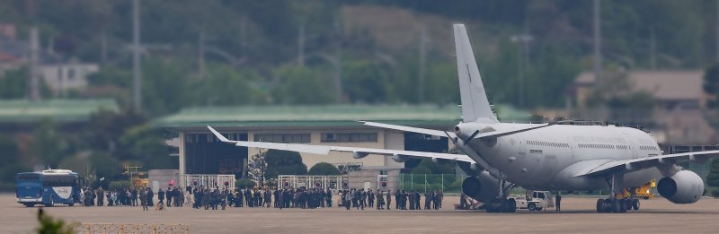군벌 간 무력 분쟁을 피해 수단을 탈출한 교민 28명이 25일 오후 서울공항에서 우리 공군의 KC-330 '시그너스' 다목적 공중급유기 편으로 입국해 기체에서 내려 버스로 이동하고 있다. 사진=연합뉴스
