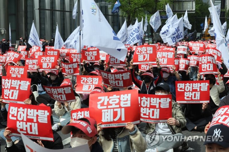 대한의사협회를 비롯한 13개 보건복지의료연대 관계자들이 지난 16일 오후 서울시청 인근에서 열린 간호법·면허박탈법 저지 400만 보건복지의료연대 총파업 결의대회에서 관련 구호를 외치고 있다. 연합뉴스 제공.