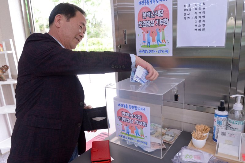 지난 24일 오후 광주 북구 운정동에 위치한 '한백년 식당'에서 한 손님이 기부함에 돈을 넣고 있다. 해당 식당은 자립 청년 지원과 농민 쌀 소비 촉진, 5·18국립묘지 참배 활성화를 위해 매주 월요일 점심식사를 1000원에 제공하고 있다. 2023.4.29/뉴스1 ⓒ News1 이승현 기자