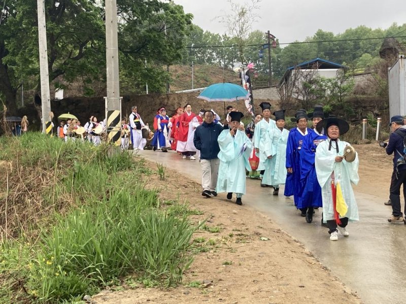 29일 충북 충주시 엄정면 주민들이 우산을 쓴 채 목계별신제가 열리는 남한강가로 행진하고 있다.(엄정면행정복지센터 제공)2023.4.29/뉴스1