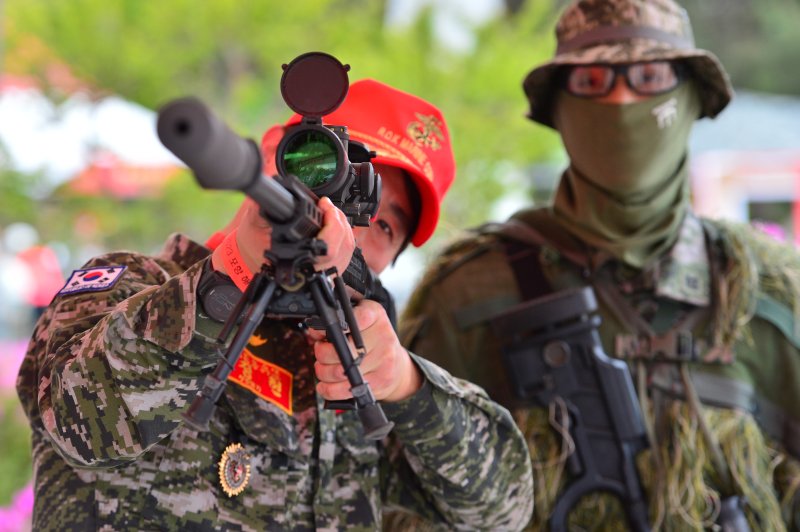 29일 오후 경북 포항시 남구 오천읍 해병대 1사단과 해병의 거리 일원에서 열린 '2023 포항해병대문화축제' 첫 날 축제장을 찾은 예비역 해병이 현역들이 사용히는 저격용 소총으로 조준해 보고 있다..2023.4.29/뉴스1 ⓒ News1 최창호 기자