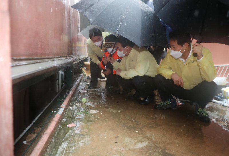 윤석열 대통령이 지난해 여름 간밤 폭우로 일가족 3명이 사망한 서울 관악구 신림동의 다세대 주택 현장을 찾아 상황 설명을 듣고 있다. 오른쪽은 오세훈 서울시장. (대통령실사진기자단) 2022.8.9/뉴스1 ⓒ News1 오대일 기자