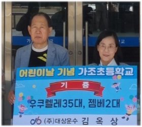 ㈜대상운수 김옥상 회장(왼쪽)이 모교인 거창 가조초등학교에 우쿨렐레 35대와 젬베 2대를 기증하며 기념촬영을 하고 있다. 대상운수 제공