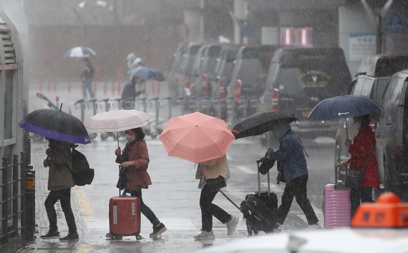 어린이날 황금연휴를 앞둔 4일 오전 제주국제공항 1층 도착장에 우산을 쓴 관광객들이 발걸음을 재촉하고 있다. 기상청에 따르면 오는 6일 오전까지 제주를 포함한 전국 대부분 지역에 강한 바람을 동반한 많은 비가 내릴 것으로 전망된다. 뉴시스