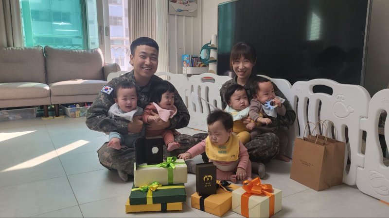 윤석열 대통령 부인 김건희 여사가 우리나라에서 34년 만에 태어난 다섯쌍둥이의 첫 생일을 맞아 직접 쓴 축하 손편지와 생일선물, 대통령 명의의 시계를 선물했다고 12일 대통령실이 밝혔다. 다섯쌍둥이의 부모인 김진수 대위와 서혜정 대위가 기념촬영을 하고 있다.사진=뉴시스