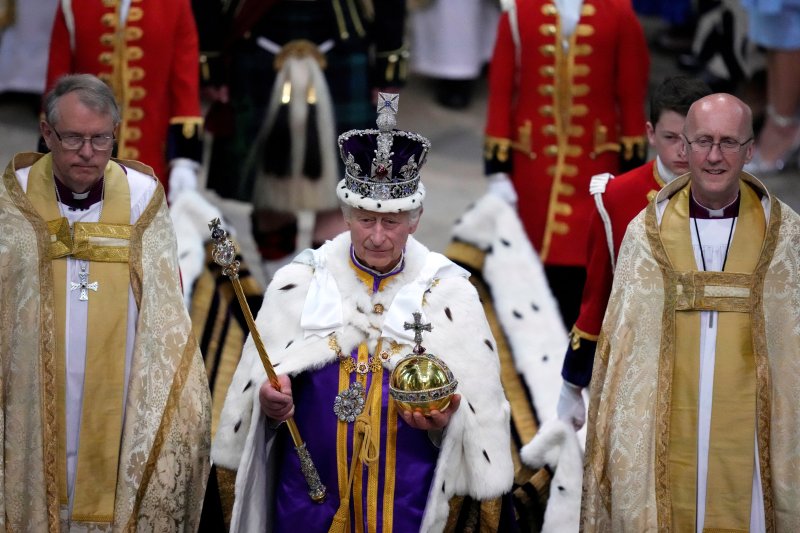 영국의 찰스 3세 국왕(가운데)이 6일(현지시간) 수도 런던 웨스트민스터 사원에서 왕관을 쓰고 행진하고 있다.로이터뉴스1