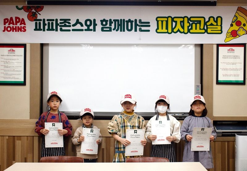 파파존스 피자교실에 참석한 아이들이 기념촬영을 하고있다.