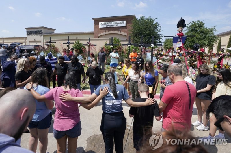 텍사스 쇼핑몰 앞에서 희생자 위해 기도하는 사람들 A large group of visitors are led in prayer at a makeshift memorial by the mall where several people were killed, Monday, May 8, 2023, in Allen, Texas. (AP Photo/Tony Gutierrez)