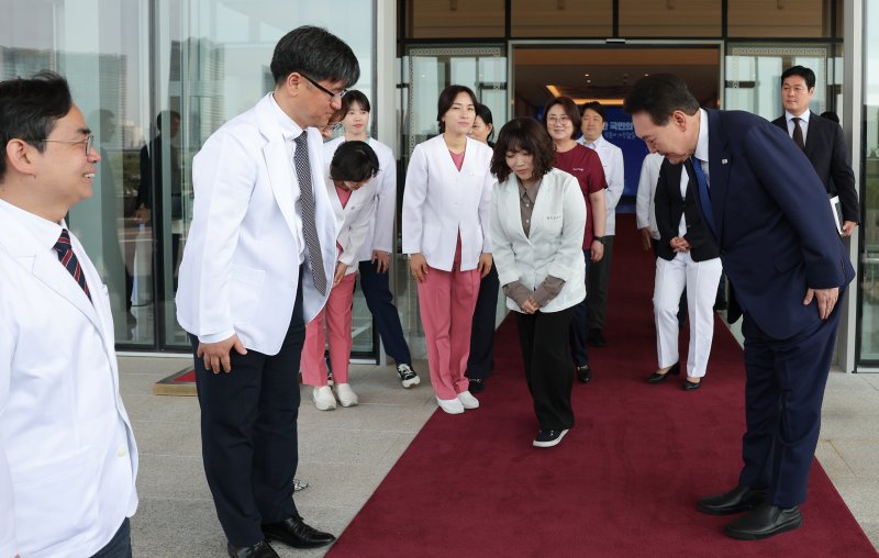 윤석열 대통령이 지난 5월11일 서울 용산 대통령실 청사에서 코로나19 중앙재난안전대책본부 회의를 마친 뒤 코로나19 최전선에서 활약한 보건 의료진을 환송하고 있다. [대통령실 제공] 연합뉴스