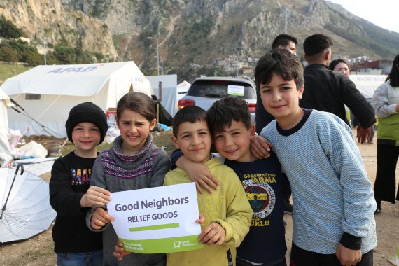 굿네이버스가 튀르키예 안타키아 지역에서 이재민들에게 전달한 긴급구호물품을 받고 환한 미소를 짓고 있는 아이들 /사진=굿네이버스