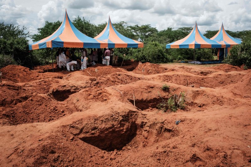 (FILES) In this file photo taken on April 25, 2023 Workers take shelter while digging the ground to exume bodies from the mass-grave site in Shakahola, outside the coastal town of Malindi. The death toll in an investigation linked to a Kenyan cult that practised starvation has climbed to 201, as inv