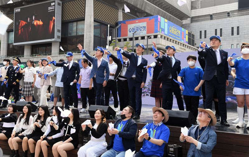 지난 13일 서울 광화문광장에서 열린 '푸른코끼리 비폭력 캠페인'에 참가한 관계자들이 청소년들과 함께 비폭력 문구가 적힌 종이비행기를 날리는 퍼포먼스를 하고 있다. 삼성전기 제공